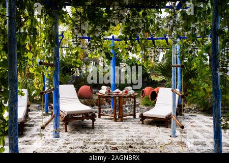 cozy spa area with two wooden bed-chairs, towels on a bamboo table, huge vases Stock Photo