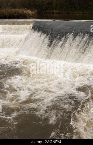 Fast flowing river irwell plunging over weir and aerating river downstream in burrs country park bury lancashire uk Stock Photo