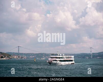 Bosphorus Bridge, Istanbul ,Turkey - October 2019 : Tourist yacht sailing famous asian bridge long-shot Stock Photo