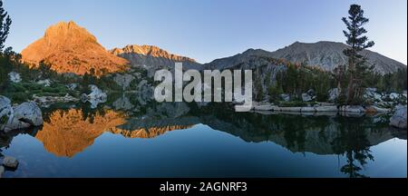 panorama of fifth lake in the north fork of Big Pine Creek drainage with Two Eagle Peak and Cloudripper Mountain lit up by morning sun Stock Photo