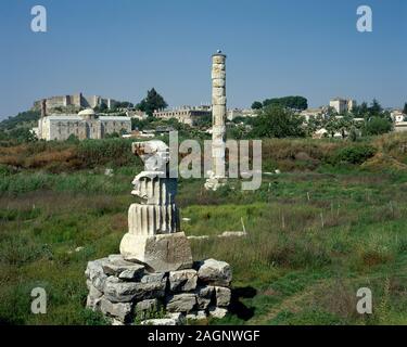 Turkey, Ephesus (modern Selçuk). Temple of Artemis or Artemision. Greek temple. One of The Seven Wonders of the Ancient World. Remains of the colossal column. In the background Isa Bey Mosque and the Byzantine Castle. Stock Photo