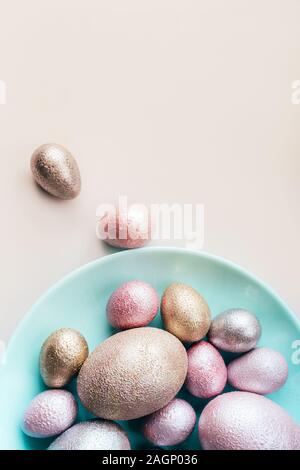 Colored chicken and quail eggs of pink, silver, golden and blue color  Stock Photo
