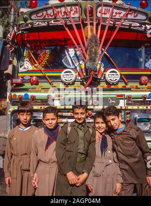 Syria. Pleasant street scenes in old Damascus of young boys in quasi style scout uniforms pose against a highly decorated local bus Stock Photo
