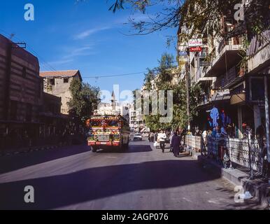 Syria. Pleasant street scenes in old Damascus with apartment buildings and multi-coloured local bus service Stock Photo