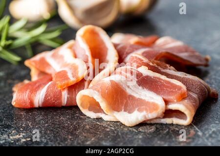 Smoked bacon strips on old kitchen table. Stock Photo