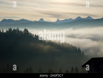 Fogs and sunlight over Emmental hills with view of the world famous mountains Eiger, Monch and Jungfrau Stock Photo