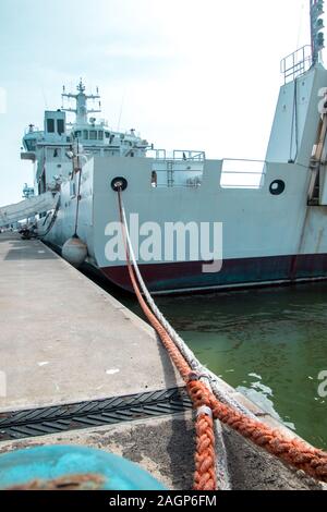 A view along ropes that are being used to moor a large ship, in a harbor. Stock Photo