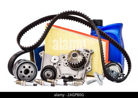 Various spare parts for the car. The set of timing belt with rollers, cooling pump, motor oil, sparking plugs and filters on a white background. Stock Photo