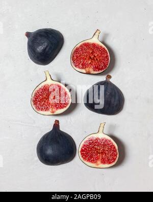 Fresh figs on grey concrete background. Food Photo. Purple figs with red seeds. Flat lay, top view. Food concept. Stock Photo