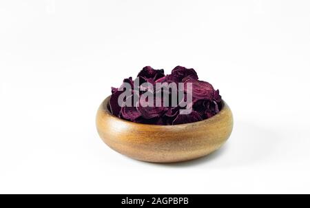 Dried beet chips in a wooden bowl on a white background. Vegetarian diet food. Horizontal orientation with copy space. Close up. Stock Photo
