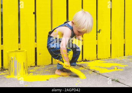 Two Year Old Boy Painting a Fence Yellow Stock Photo