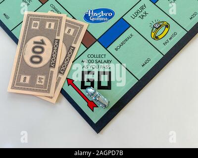 Orlando, FL/USA-12/20/19:  The race car  on the Passing Go square for the game Monopoly by Hasbro on a white background.  Concept business, banking, a Stock Photo