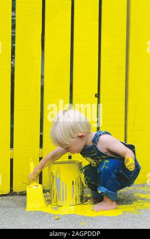 Two Year Old Boy Painting a Fence Yellow Stock Photo