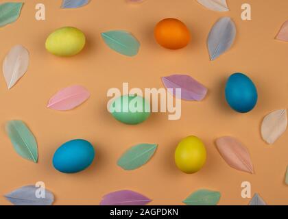 Easter composition of multicolored colorful easter eggs and feathers on pastel background. Happy Easter holidays. Stock Photo