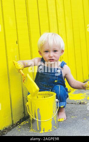 Two Year Old Boy Painting a Fence Yellow Stock Photo