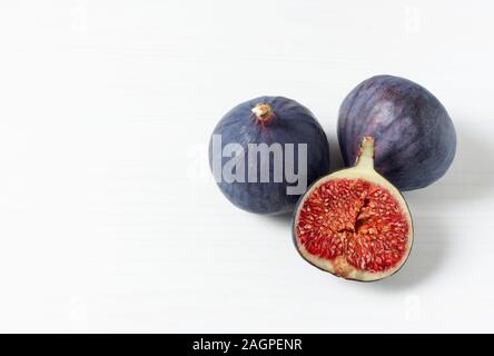 Fresh ripe figs on white background with space for text. Food Photo. Copy space. Purple figs with red seeds. Side view. Food concept. Stock Photo