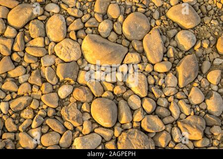 A collection of random sized stones on the ground, which will make a great background image. Stock Photo