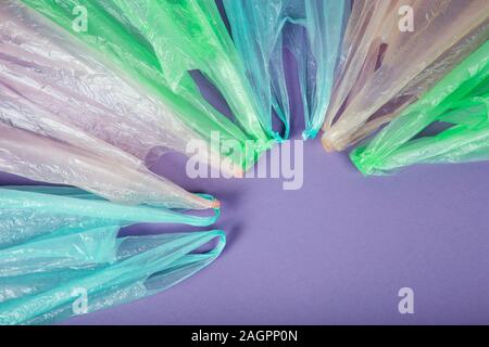 Disposable colorful plastic bags on purple background. Stock Photo