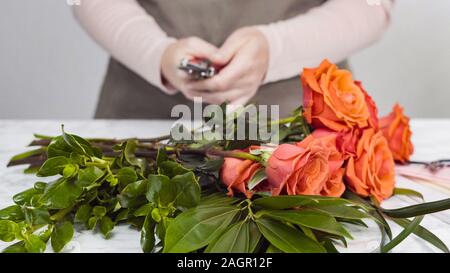 Florist running red roses for bouquet arrangement Stock Photo - Alamy