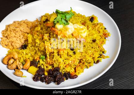 Pineapple Fried Rice, is a quick stir-fry, with Thai-inspired ingredients like jasmine rice, curry, fish sauce, red bell pepper, pineapple, peas, and Stock Photo