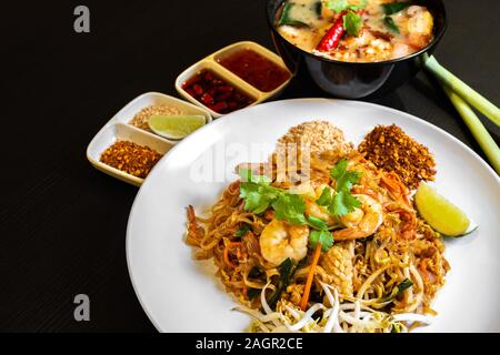 Pad thai, or phad thai, is a stir-fried rice noodle traditional dish served as a street food in Thailand. It is a stir-fry dish made with shrimp, chic Stock Photo