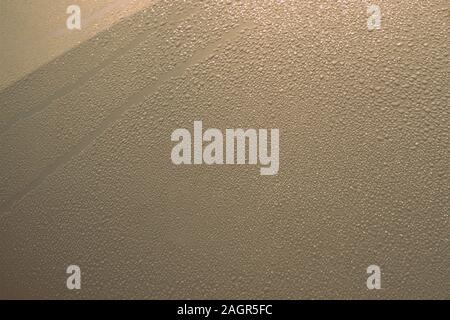 Sparkling drops of water on a metal surface illuminated by the sun close-up. Abstract background Stock Photo