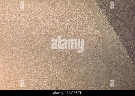 Sparkling drops of water on a metal surface illuminated by the sun close-up. Abstract background Stock Photo