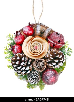 Christmas homemade fir toy  in rural style made  of dry red orange rose cones and red bell on a birch tree  slice. Isolated with patch on white studio Stock Photo