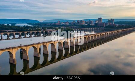 Bridge reflecting in water with Harrisburg skyline, sunrise aerial view of Harrisburg Susquehanna River Bridge, Pennsylvania, USA historic landmark Stock Photo