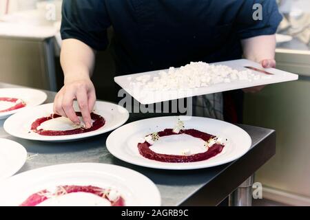 Chef is cooking set of appetizers, putting soft cheese, toned image Stock Photo