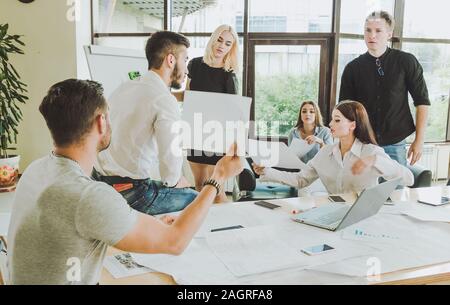 The working process. Casually dressed employees in the process of discussion of the project are bright and spacious office Stock Photo