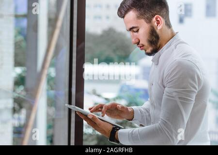 closeup of young arab ethnency man using tablet pc indoor Stock Photo