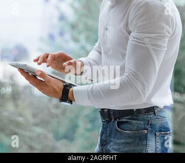 closeup of man's hands that is using tablet pc indoor Stock Photo