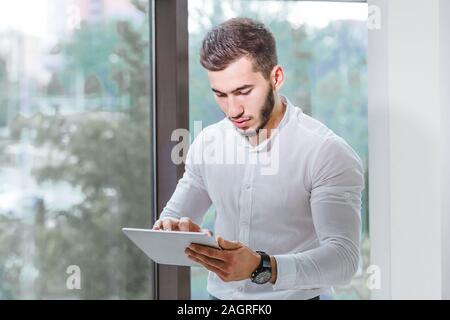 closeup of young arab ethnency man using tablet pc indoor Stock Photo