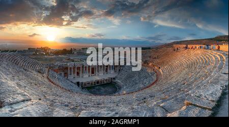 Amphitheater in ancient city of Hierapolis. Dramatic sunset sky. Unesco Cultural Heritage Monument. Pamukkale, Turkey Stock Photo