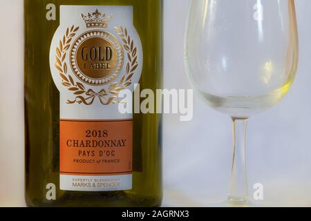 empty 2018 Gold Label Chardonnay Pays D'Oc white wine bottle and glass - product of France with Gold label - expertly blended by Marks & Spencer Stock Photo
