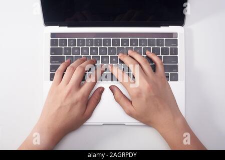 Female hands typing on a laptop keyboard. White background. Stock Photo