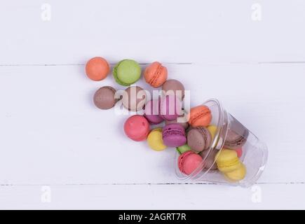 Colorful mini macarons a scattering of packaging on white background Stock Photo