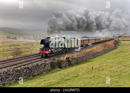 Ribblesdale, North Yorkshire, UK. 21st Dec, 2019. On a wet and murky Winter's day, The Flying Scotsman locomotive is seen with 'The Christmas Dalesman' steam special. Seen here at Selside near Horton-in-Ribblesdale in the Yorkshire Dales National Park, travelling north to Carlisle on the famous Settle to Carlisle railway line, on a round trip from Manchester. The return trip was via Shap on the West Coast main line. Credit: John Bentley/Alamy Live News Stock Photo