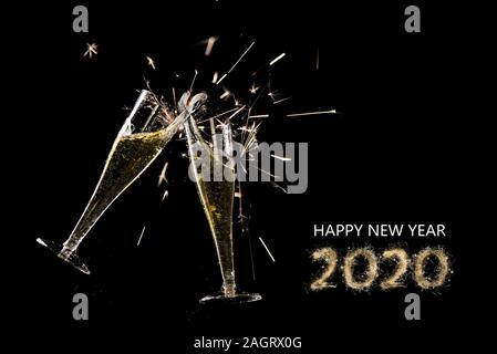happy new year 2020, two champagne flutes toast with splash and sparklers against a black background, party concept with text and copy space Stock Photo