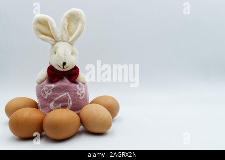 Easter rabbit with eggs isolated on white background with board to write. Traditional easter decoration Stock Photo