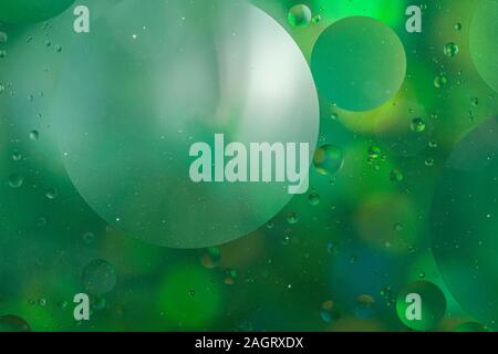 An abstract artistic close up macro photo created by mixing oil and water then back lit with a green flash