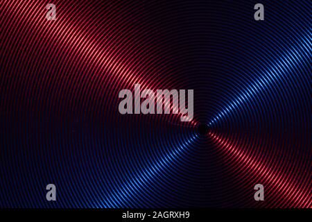 A close up macro photo of circular brushed steel metal texture with crossed red and blue lines Stock Photo