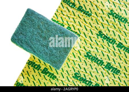 London, UK - December 20, 2019: Scotch Brite sponge abrasive surface laid on top of a cleaning cloth, isolated on white background - flat lay, top dow Stock Photo