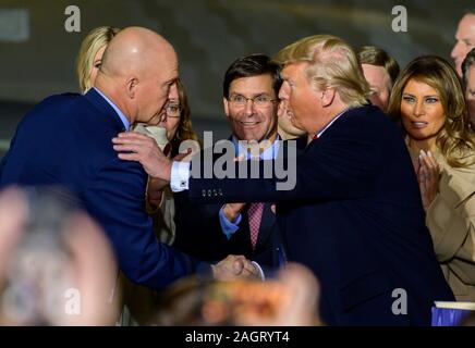 United States President Donald J. Trump congratulates US Space Force General John W. 'Jay' Raymond, Commander of the US Space Force, left, after making remarks and signing S.1790, the National Defense Authorization Act for Fiscal Year 2020 at Joint Base Andrews in Suitland, Maryland on Friday, December 20, 2019. US Secretary of Defense Dr. Mark T. Esper looks on from center. First lady Melania Trump is visible at far right.Credit: Ron Sachs/CNP | usage worldwide Stock Photo