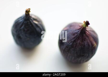 Two ripe sweet figs on white table. Selective soft focus. Stock Photo