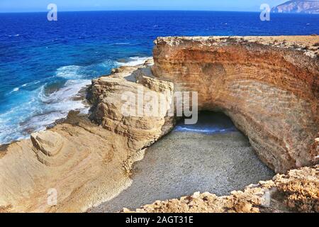 the famous Gala beach at Ano Koufonisi island Greece - the sea enters the beach via a narrow corridor of the open cave of the rocks Stock Photo