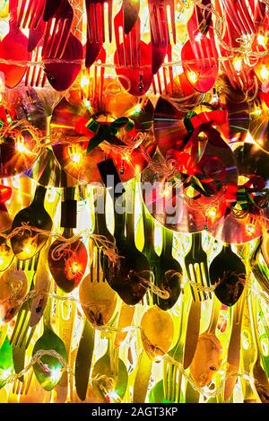 Close-up of a Christmas decoration of recycled utensils and compact discs combined with warm Christmas lights, seen in the Philippines Stock Photo