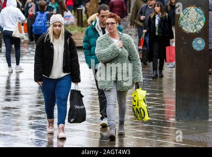 Bath, Somerset, UK. 21st December, 2019. Shoppers are pictured in Bath braving heavy rain showers as they visit the shops on the last Saturday before Christmas. The last Saturday before Christmas has become known as ‘Panic Saturday' and many stores have  reduced prices to attract last minute customers. Credit: Lynchpics/Alamy Live News Stock Photo