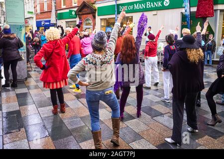 Members of the Isle of Man extinction rebellion group dancing in Strand Street to Staying Alive during peak Christmas Shopping in December 2019 Stock Photo